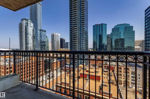 Balcony featuring a decorative black metal railing, concrete flooring, and surrounding cityscape - #1501 10180 104 St Nw, Edmonton, AB - Outdoor With Facade