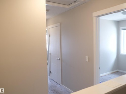Interior hallway with neutral tone walls and white trim - 17263 9 Avenue Sw, Edmonton, AB 