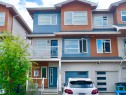 Contemporary townhouse exterior featuring a multi-tone facade with wood-look siding and blue accents - 17263 9 Avenue Sw, Edmonton, AB 