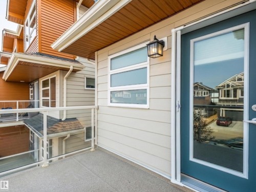 Private balcony featuring a textured concrete surface and glass panel railing - 17263 9 Avenue Sw, Edmonton, AB 