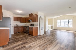 Open-concept living area with wood-finish flooring, vaulted ceiling, and recessed lighting - 
