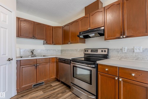 Kitchen featuring wood-finish cabinetry, light gray countertops, and a white subway tile backsplash - #D 10102 103 St, Morinville, AB - Indoor Photo Showing Kitchen