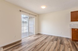 Spacious interior with wood-finish flooring, a contemporary ceiling light fixture, and a sliding glass door - 