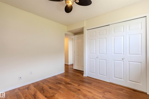 Interior space featuring wood-finish flooring, light-toned walls, and a ceiling fan with integrated lighting - #D 10102 103 St, Morinville, AB - Indoor Photo Showing Other Room