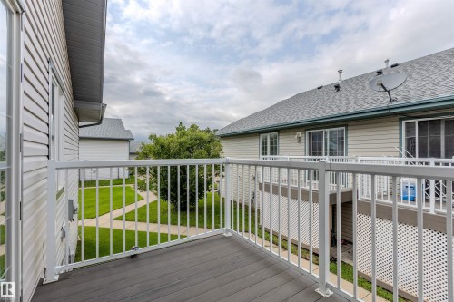 Private balcony featuring dark composite decking and white aluminum railings - #D 10102 103 St, Morinville, AB - Outdoor With Deck Patio Veranda With Exterior