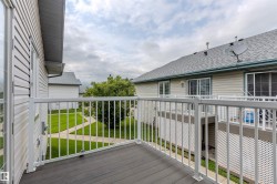 Private balcony featuring dark composite decking and white aluminum railings - 