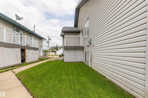 Exterior showcasing horizontal siding, a balcony with white railings, and a lower-level white lattice enclosure - #D 10102 103 St, Morinville, AB - Outdoor With Balcony With Exterior
