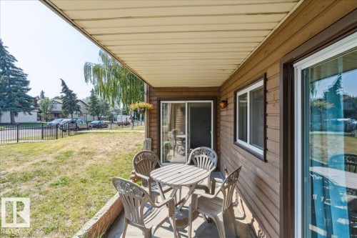 Covered patio featuring a wood-finish plank ceiling and wood-paneled exterior - #112 2904 139 Av Nw, Edmonton, AB - Outdoor With Deck Patio Veranda With Exterior
