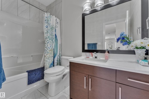 Bathroom featuring a white bathtub and an integrated toilet - 3001 55 Street, Beaumont, AB - Indoor Photo Showing Bathroom
