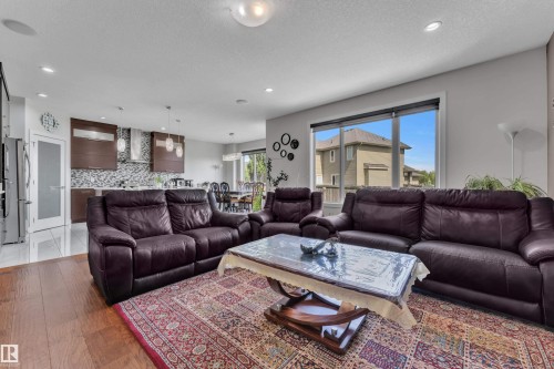 Open-concept living area featuring wood-finish flooring, recessed lighting, and large windows - 3001 55 Street, Beaumont, AB - Indoor Photo Showing Living Room
