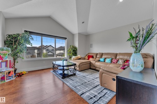 Spacious living area featuring vaulted ceilings, wood-finish flooring, and a large multi-pane window - 3001 55 Street, Beaumont, AB - Indoor Photo Showing Living Room