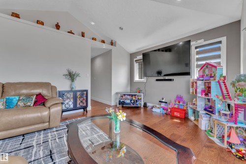 Vaulted ceilings with an integrated display ledge, wood-finish flooring, and light gray walls - 3001 55 Street, Beaumont, AB - Indoor Photo Showing Other Room