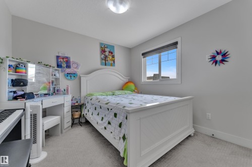 Bedroom featuring a white arched headboard, a window with a black roller blind, light gray wall paint, and gray carpet flooring - 3001 55 Street, Beaumont, AB - Indoor Photo Showing Bedroom