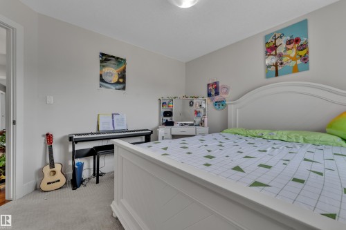 Light gray wall color with recessed ceiling lighting, a white painted headboard, and light carpet flooring - 3001 55 Street, Beaumont, AB - Indoor Photo Showing Bedroom