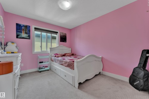 Spacious bedroom featuring light pink walls and light gray carpet - 3001 55 Street, Beaumont, AB - Indoor Photo Showing Bedroom