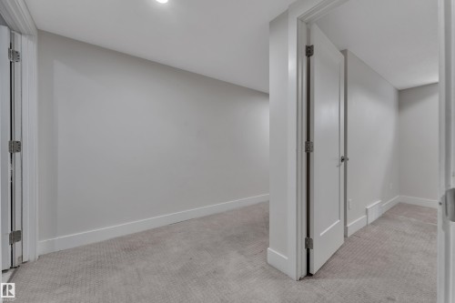 Neutral gray walls with white trim, light gray patterned carpeting, and recessed lighting - 3001 55 Street, Beaumont, AB - Indoor Photo Showing Other Room