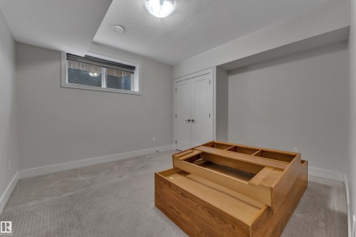 Carpeted room with a window, white baseboards, and a white ceiling with a flush-mount light fixture - 3001 55 Street, Beaumont, AB - Indoor Photo Showing Other Room