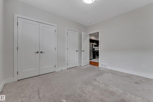 Neutral gray wall paint with white trim, light-toned carpet, and a white flush-mount ceiling light - 3001 55 Street, Beaumont, AB - Indoor Photo Showing Other Room