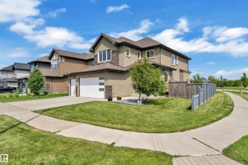 Contemporary residence featuring a two-car garage, stucco and stone-veneer exterior, and a fenced side yard - 3001 55 Street, Beaumont, AB - Outdoor