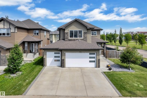 Contemporary two-story residence with a multi-car garage, featuring a concrete driveway and stone accents on the facade - 3001 55 Street, Beaumont, AB - Outdoor With Facade