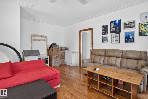 Living area featuring wood-finish flooring, white walls, and white crown molding - 12229 88 Street Nw, Edmonton, AB - Indoor