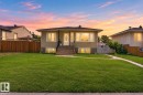 Stucco exterior residence featuring a front yard with a concrete walkway, established lawn, and a light-colored front door with an oval glass insert - 12229 88 Street Nw, Edmonton, AB  - Outdoor 