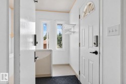 Entryway featuring a paneled door with an arched window, a digital lock, and a matte black handle - 