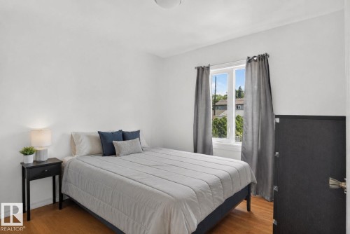 Bedroom featuring light wood-finish flooring and a single window with white trim - 12229 88 Street Nw, Edmonton, AB - Indoor Photo Showing Bedroom