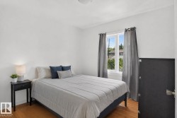 Bedroom featuring light wood-finish flooring and a single window with white trim - 