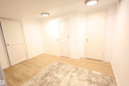 Light wood-finish flooring - 12229 88 Street Nw, Edmonton, AB - Indoor Photo Showing Other Room