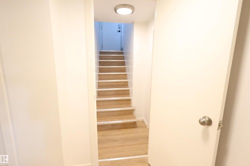 Staircase featuring wood-finish treads and risers, illuminated by a flush-mount ceiling light - 12229 88 Street Nw, Edmonton, AB - Indoor Photo Showing Other Room