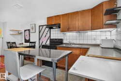 Kitchen featuring wood cabinetry, white tile backsplash, a black range, and an integrated stainless steel sink - 