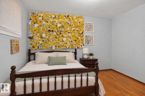 Bedroom featuring wood-finish flooring, light blue wall paneling, and a single window with blinds - 12229 88 Street Nw, Edmonton, AB - Indoor Photo Showing Bedroom