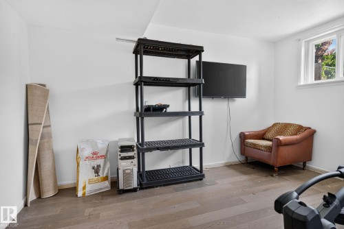 Interior space featuring white walls, wood-finish flooring, and a multi-pane window - 12229 88 Street Nw, Edmonton, AB - Indoor