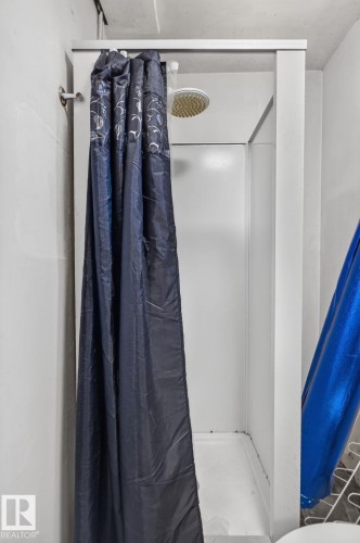 Enclosed shower stall with a white base and a rain showerhead - 12229 88 Street Nw, Edmonton, AB - Indoor