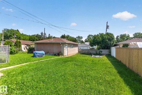 Expansive green lawn with a detached auxiliary structure featuring a shingle roof and a dedicated entrance - 12229 88 Street Nw, Edmonton, AB - Outdoor