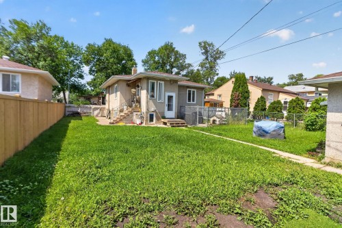 Expansive rear yard featuring a paved walkway, a wood privacy fence, and mature trees - 12229 88 Street Nw, Edmonton, AB - Outdoor