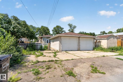 Detached two-car garage featuring a shingle roof and two white garage doors - 12229 88 Street Nw, Edmonton, AB - Outdoor