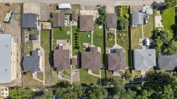 Aerial perspective showcasing multiple residential properties with varied rooflines and landscaping - 