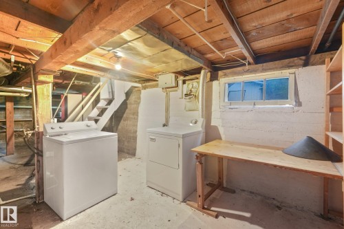 Basement utility area featuring exposed wood beams, concrete foundation walls, and a wood-finish staircase - 9824 91 Avenue Nw, Edmonton, AB - Indoor Photo Showing Laundry Room