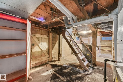 Basement utility area featuring exposed wood beam ceiling, concrete flooring, and a wooden staircase - 9824 91 Avenue Nw, Edmonton, AB - Indoor Photo Showing Basement