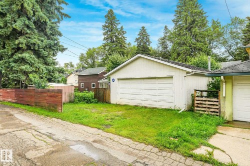 Detached garage with a white overhead door and shingled roof, accompanied by a grass area - 9824 91 Avenue Nw, Edmonton, AB - Outdoor