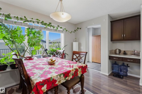 Dining area with wood-finish flooring and a built-in serving station featuring dark wood cabinetry and a light-colored countertop - 1528 35 Avenue Nw, Edmonton, AB - Indoor Photo Showing Dining Room