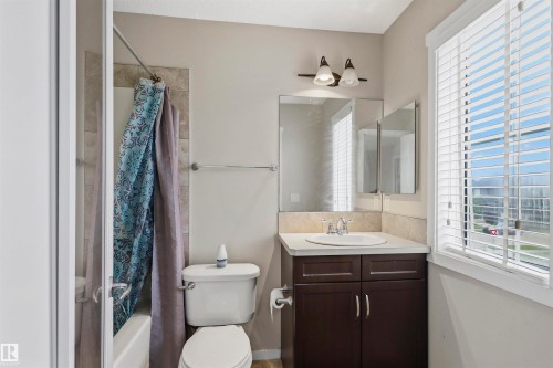 Bathroom featuring a white vanity with a dark wood-finish cabinet, a white ceramic sink, and a chrome faucet - 1528 35 Avenue Nw, Edmonton, AB - Indoor Photo Showing Bathroom