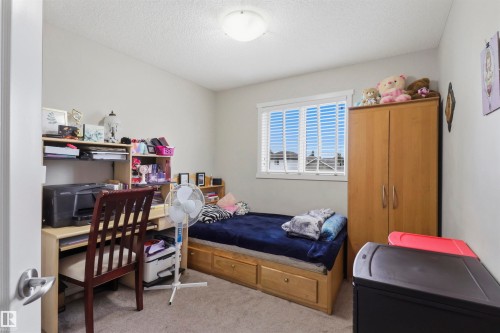 Carpeted room with a ceiling-mounted light fixture, a window featuring white blinds, and light-toned wall paint - 1528 35 Avenue Nw, Edmonton, AB - Indoor Photo Showing Bedroom