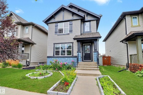 Two-story residence featuring light gray siding, dark trim accents, and blue decorative shingles - 1528 35 Avenue Nw, Edmonton, AB - Outdoor With Facade