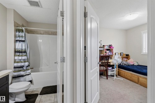 Bathroom featuring a white tub and shower unit with tile surround - 1528 35 Avenue Nw, Edmonton, AB - Indoor Photo Showing Bathroom