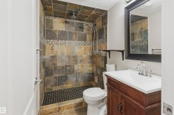 Full tile shower surround with a mosaic accent band, integrated showerhead, and handheld shower sprayer - 