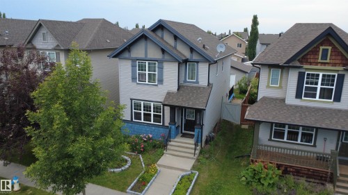 Two-story property with gray siding and blue trim accents, featuring a gabled roofline and multiple windows with white frames - 1528 35 Avenue Nw, Edmonton, AB - Outdoor With Facade