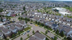 Residential neighborhood featuring a variety of single-family homes with pitched roofs, front yards, and mature trees lining the streets - 